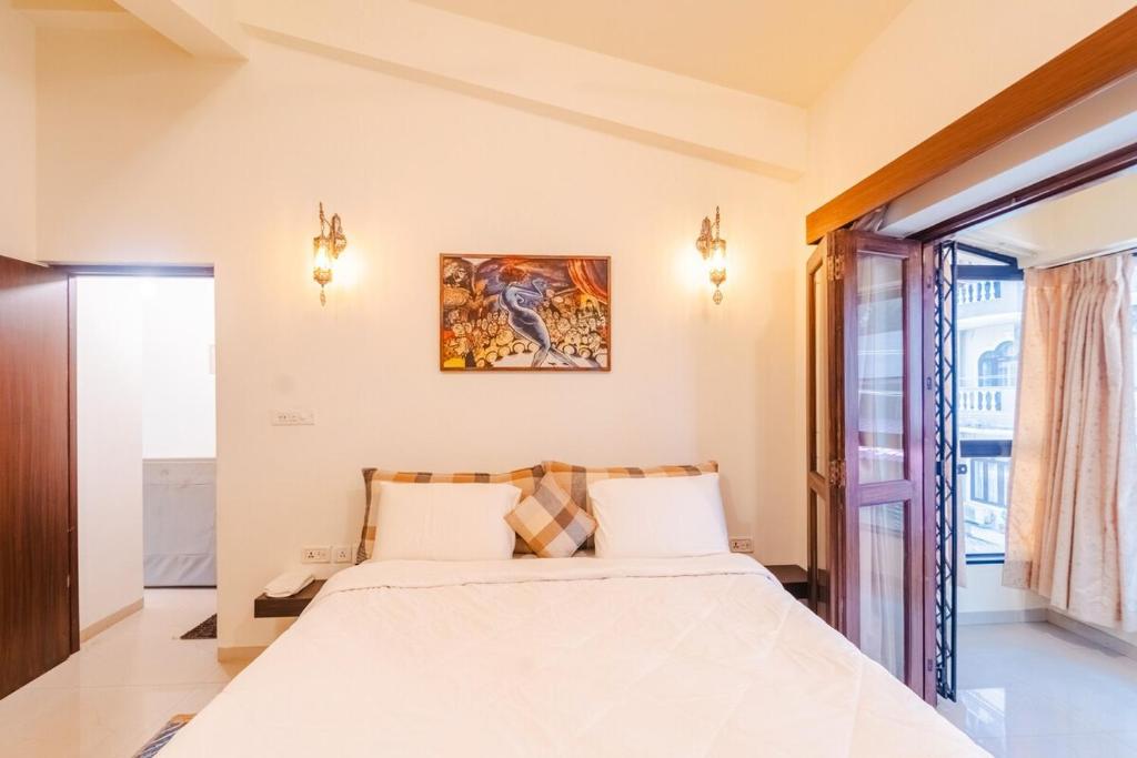 a bedroom with a bed and a window at Cabatales - 3BHK Villa Near Candolim Beach in Candolim