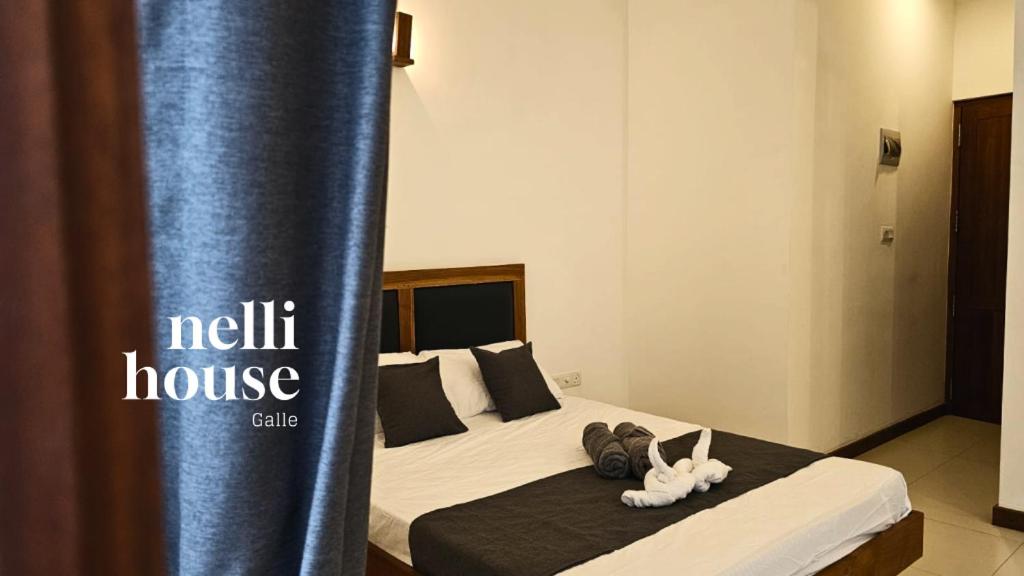 a bed with two stuffed animals sitting on top of it at nelli house in Galle