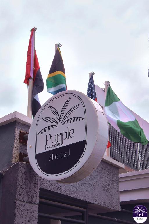 a sign for a hotel with flags on top of a building at Purple Lavender Hotel Lekki in Lekki