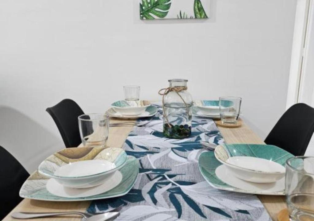 einen Esstisch mit Tellern und Gläsern darauf in der Unterkunft Ipoh Anderson Condo - 2BR in Ipoh