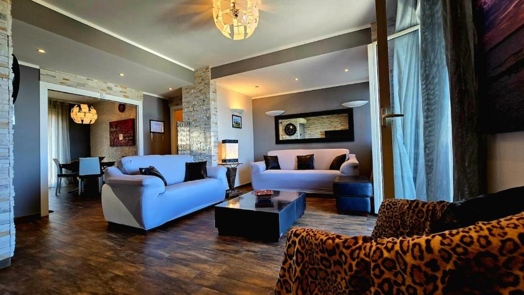 a living room with two couches and a table at Nizzeti Home Catania Sicily Sea View in Aci Catena