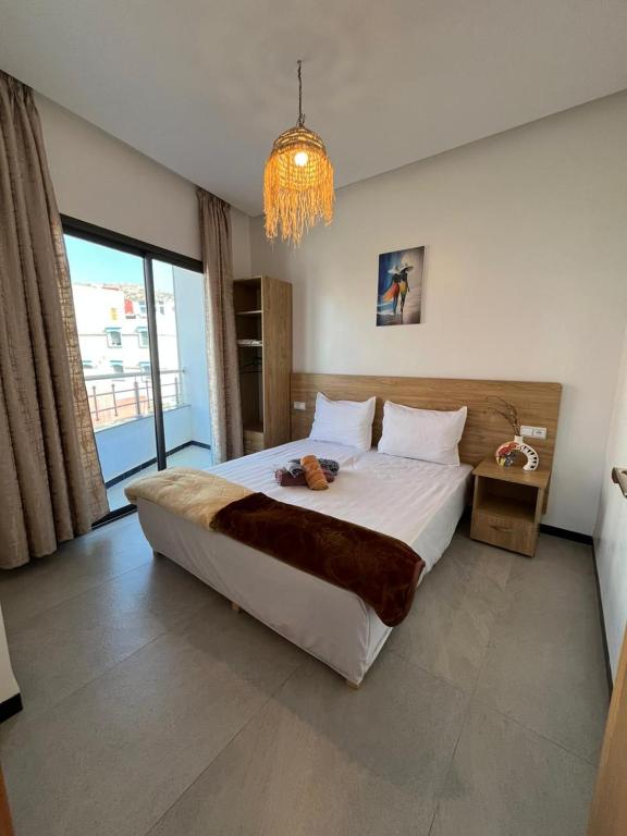 a bedroom with a large bed and a chandelier at Atlantic view Tamraght 1 in Tamraght Ou Fella