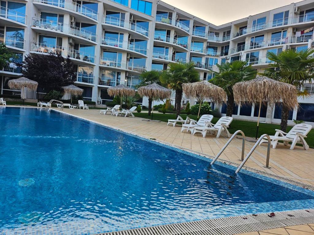 a swimming pool in front of a large apartment building at Студио за двама в Сарафово in Burgas City