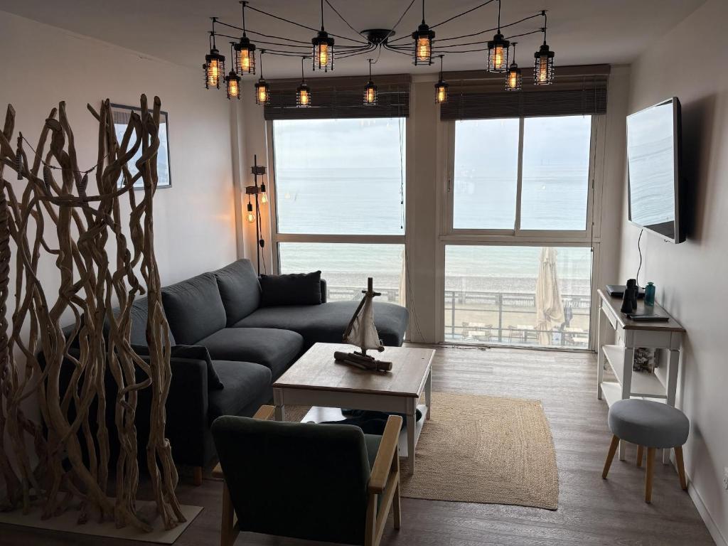 una sala de estar con un sofá y una mesa en Gîte Les pieds dans l eau à Fécamp avec pleine vue mer, en Fécamp