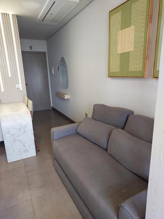 a living room with a couch and a table at Loft av central in Xangri-lá