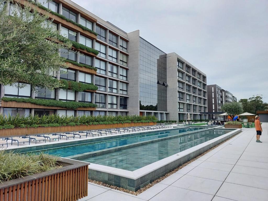 a swimming pool in front of a building at Loft av central in Xangri-lá