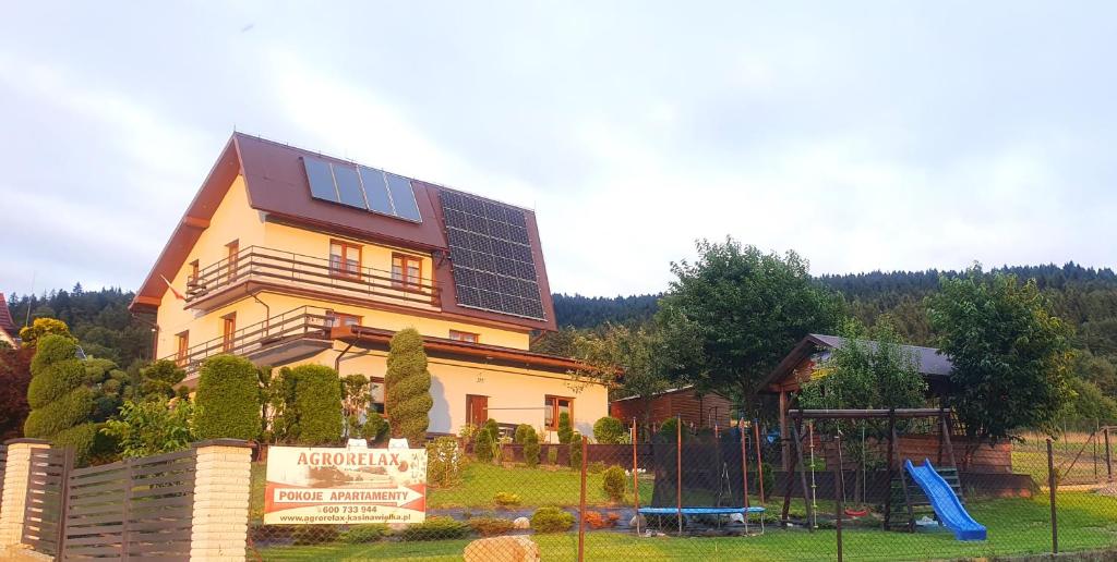 a house with solar panels on it with a playground at Agrorelax - Kasina Wielka in Kasina Wielka