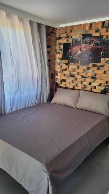 a bed in a room with a wall with cars on it at Garagem 36 próximo a Serra do Rio do Rastro in Louro Müller