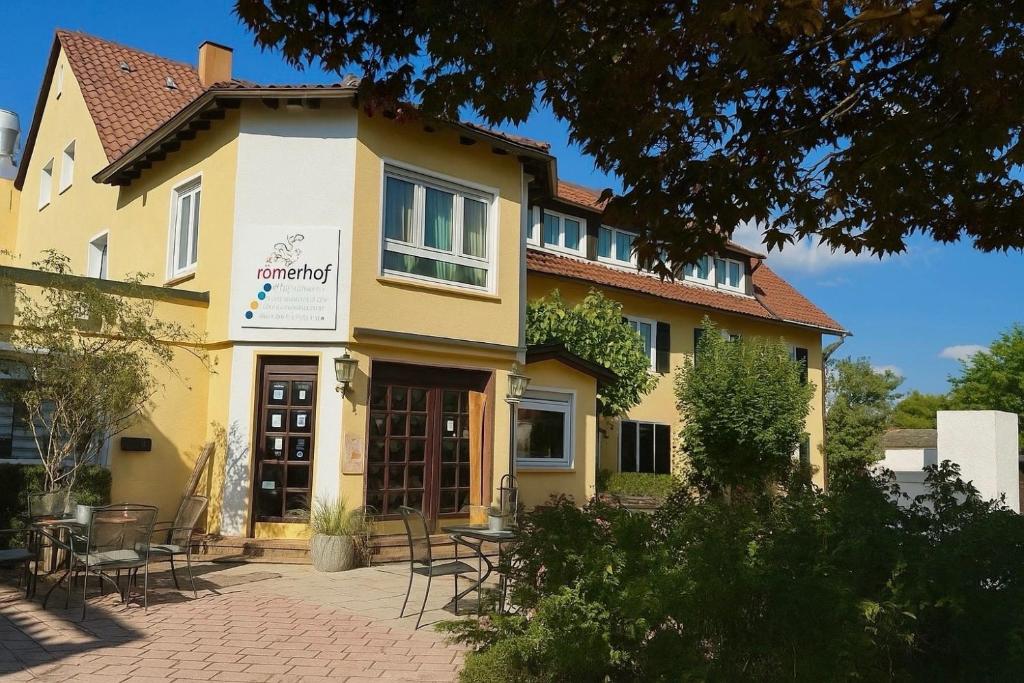 a building with tables and chairs in front of it at Römerhof in Stuttgart