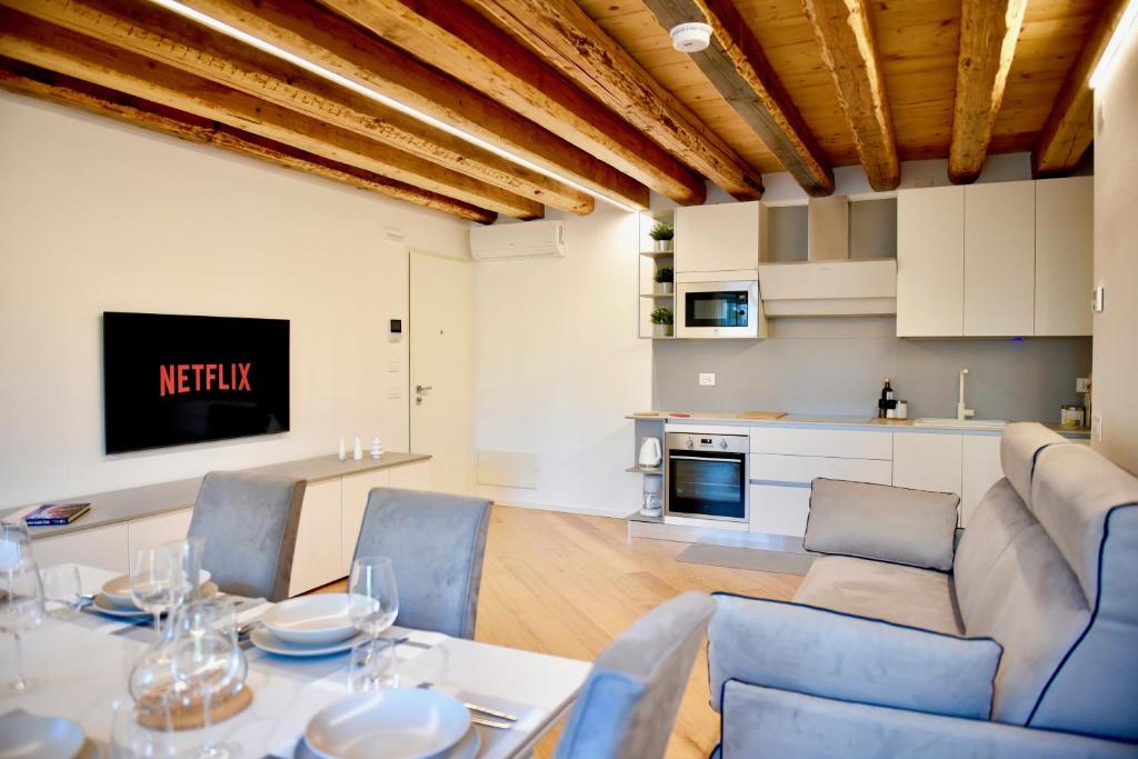 a living room with a table and chairs and a kitchen at Udine Urban Nest in Udine