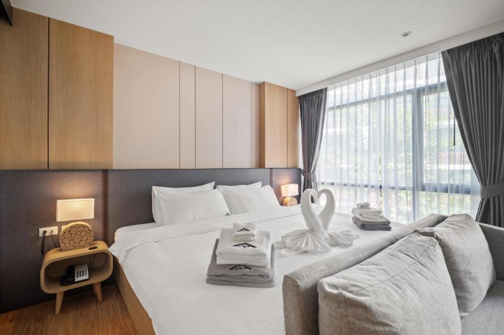 a hotel room with a large bed and a large window at 1412 Wyndham Gardens Elegant Pool Condo in Nai Thon Beach