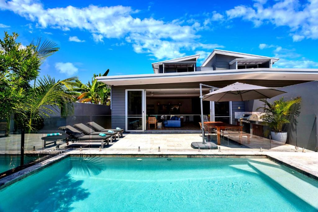 una villa con piscina y una casa en Stonecutters 2, en Byron Bay