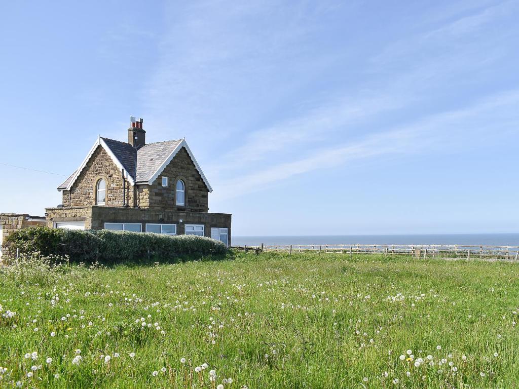 a house on the beach with a field of flowers at Toll Bar Cottage in Whitby