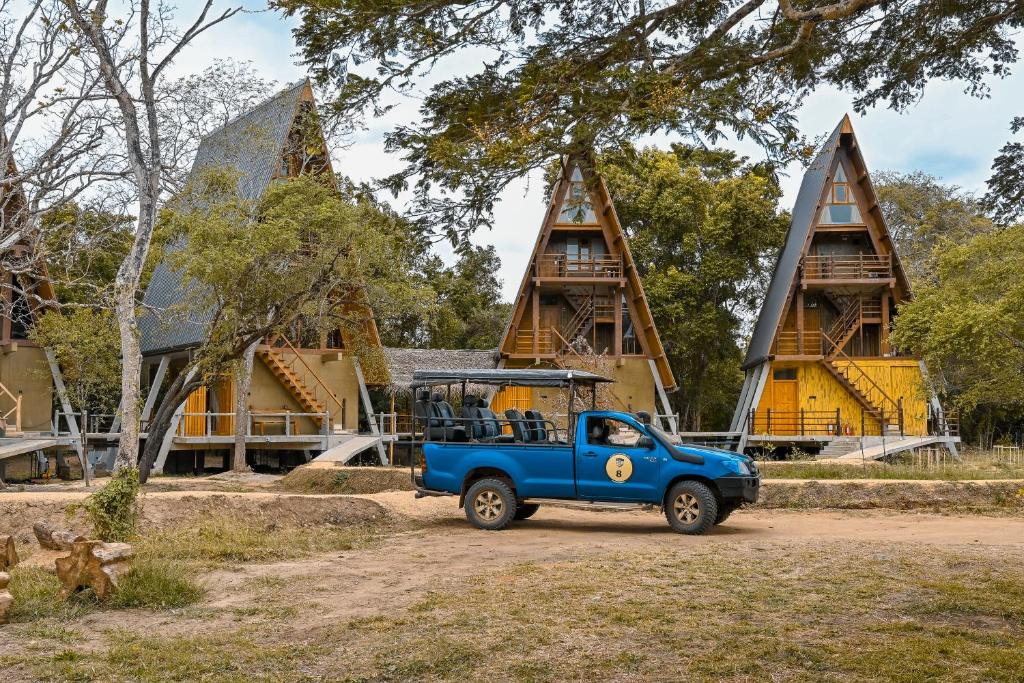 een blauwe truck geparkeerd voor een gebouw bij Wilpattu Safari Resort in Wilpattu