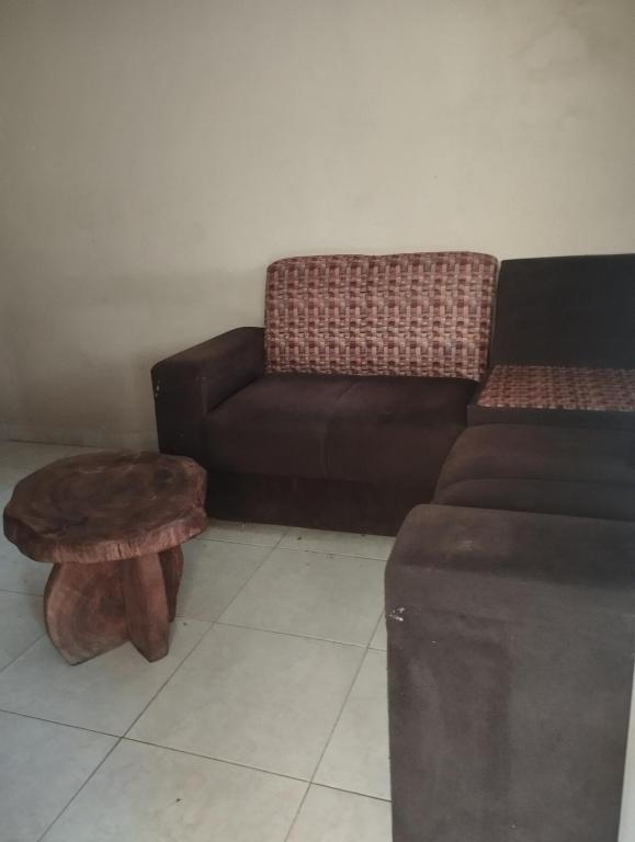 a living room with a couch and a stool at Casa de Temporada in Aracaju