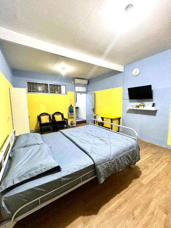 a bedroom with a large bed with yellow and blue walls at Zona Bobo Yellow Cream Cheese Moslem Friendly By Belgareti in Cimareme