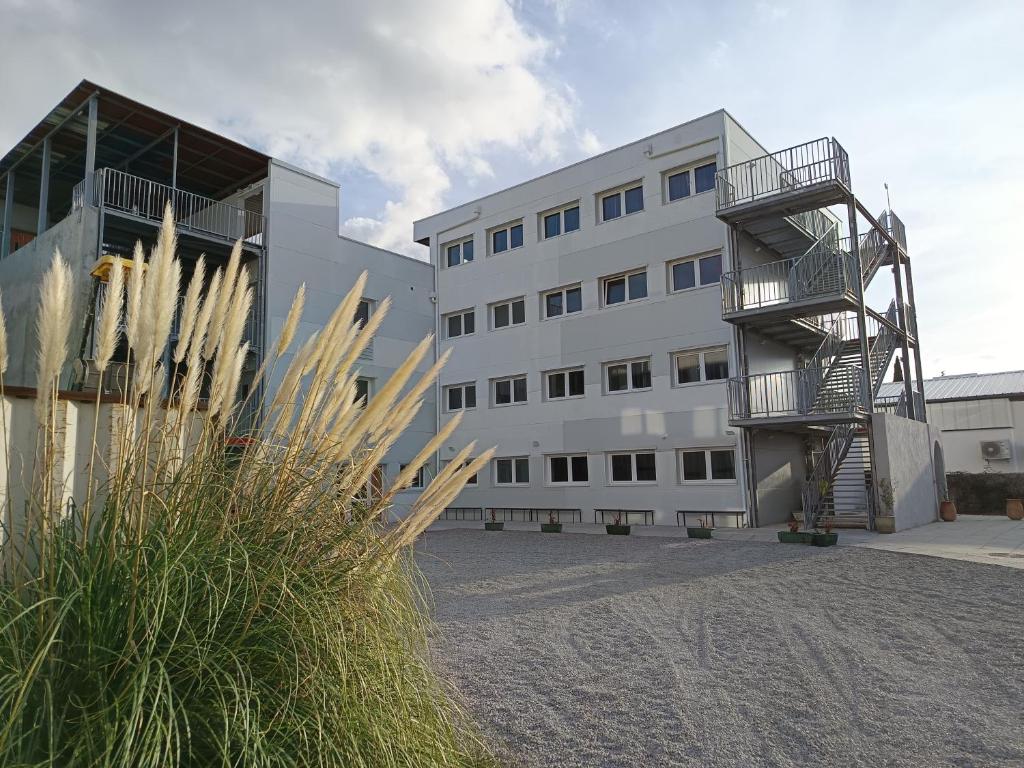 un gran edificio blanco con una escalera de caracol delante de él en Arkenciel, en Mudaison