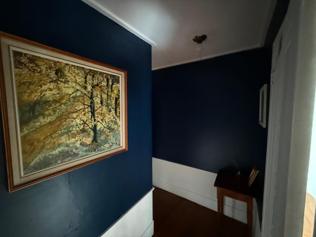 a painting on a blue wall in a bathroom at The Copper Swan in Wellfleet