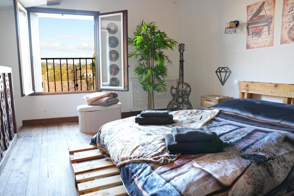 a bedroom with a large bed and a window at Cocon en bois Majeur - 4 couchages au cœur de Limoux in Limoux