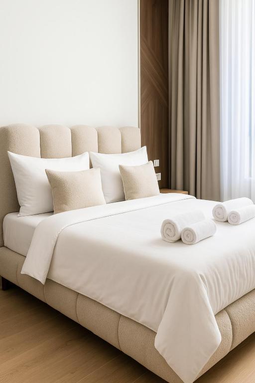 a bedroom with a large white bed with towels on it at Belgrade Waterfront - River Residences in Belgrade