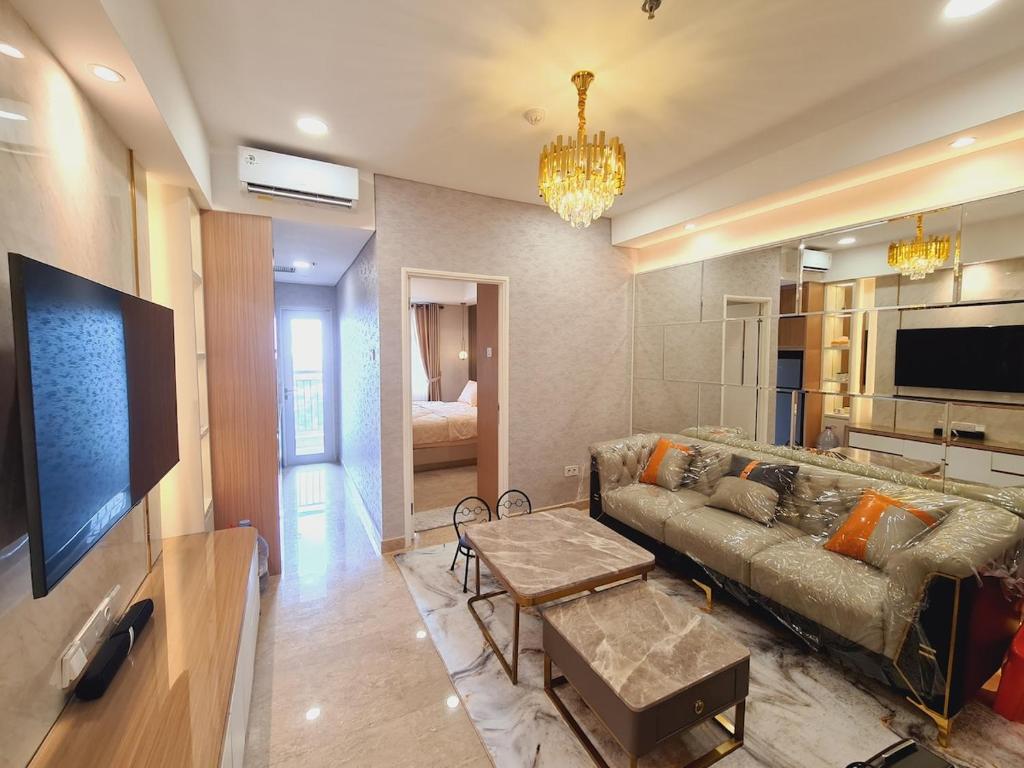 a living room with a couch and a tv at Apartment Podomoro Lincoln Delipark in Medan