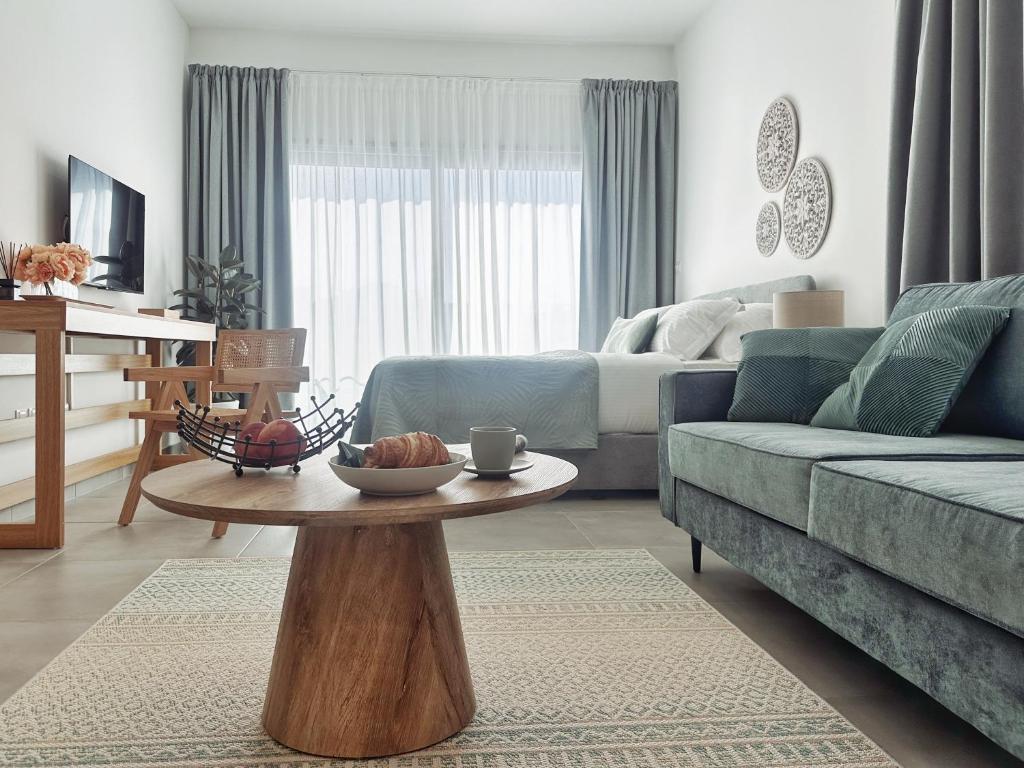 a living room with a blue couch and a table at Grace Living Studio 201 in Limassol