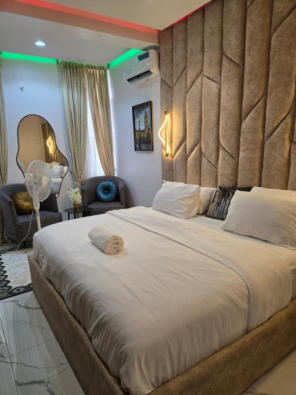 a bedroom with a large bed with a large headboard at D' Cynosure in Lekki