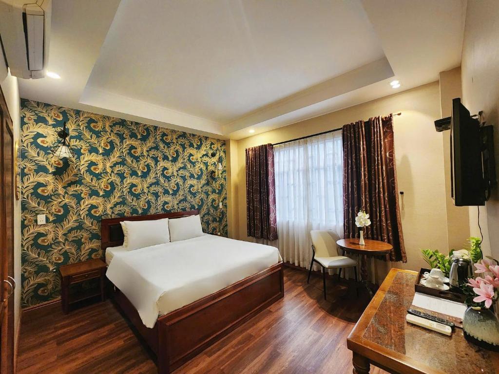 a hotel room with a bed and a desk at KAS Luxury Hotel in Ho Chi Minh City