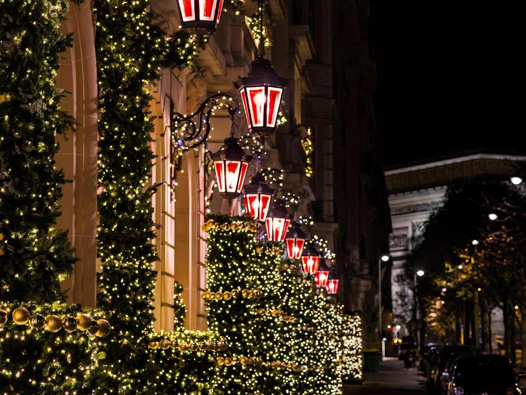 a row of christmas trees on a building with lights at Hôtel Le Royal Monceau Raffles Paris in Paris