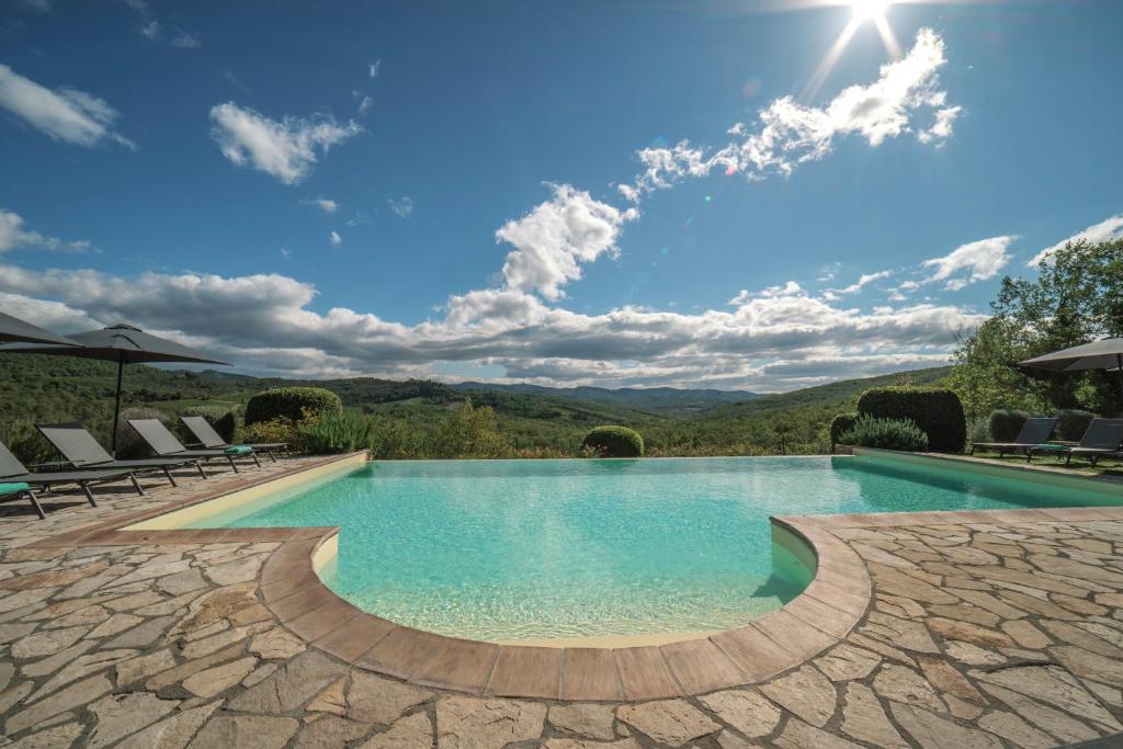 a swimming pool with a view of the mountains at Borgo Le Noci Chianti Retreat & Pool in Gaiole in Chianti