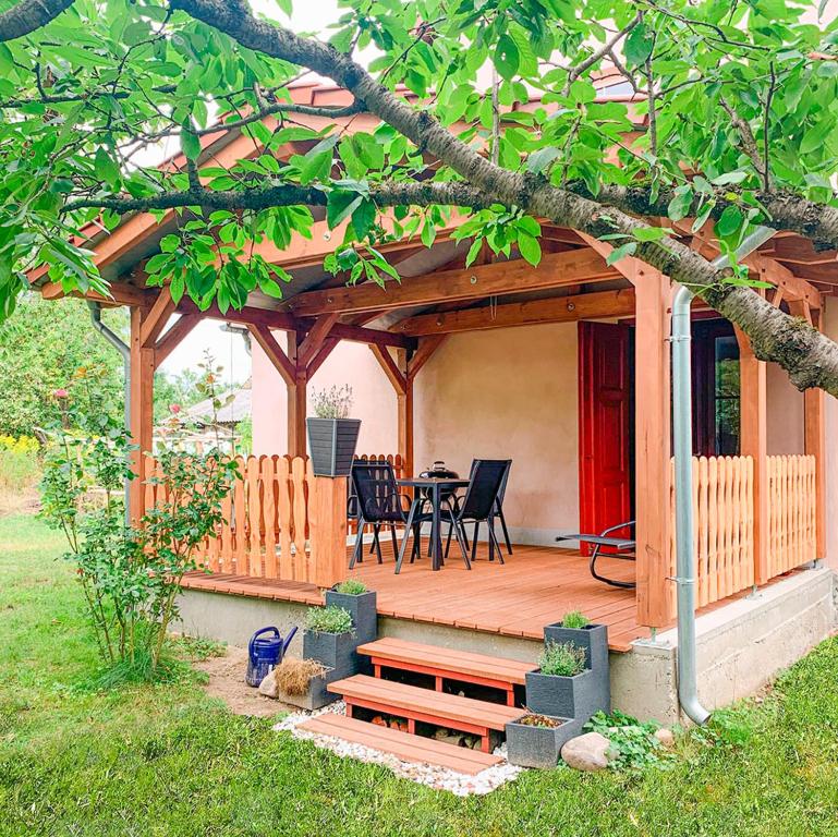 a wooden deck with a table and a bench at FeWo Feldblick in Rutenberg