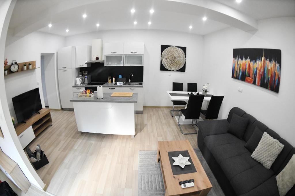 a living room and kitchen with a couch and a table at Apartman LUCIA 2 in Ðakovo