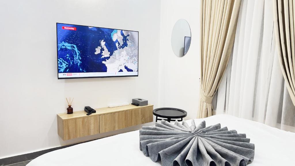 um quarto com uma televisão numa parede branca em GPR Suites & Apartments em Abuja