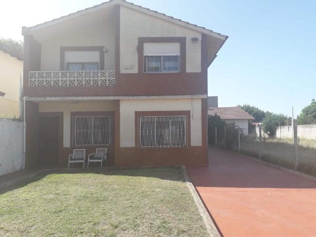 a house with two chairs in front of it at Departamentos Tala y Tuyú in San Clemente del Tuyu