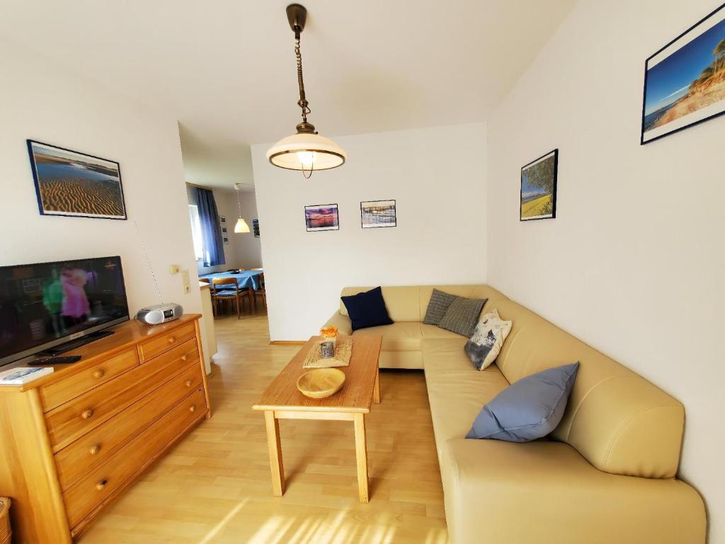 un salon avec un canapé et une télévision dans l'établissement Sundby, à Lemkenhafen auf Fehmarn