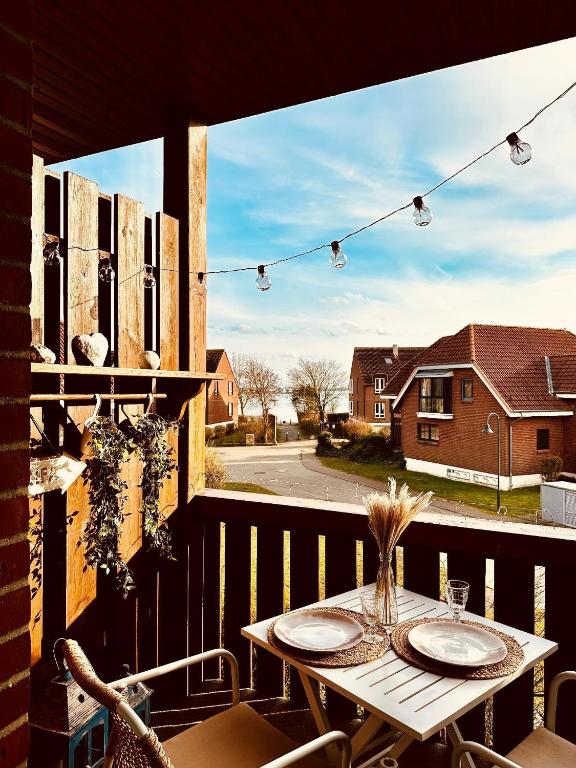 a table on a balcony with a view of a street at Havnkoje in Lemkenhafen auf Fehmarn