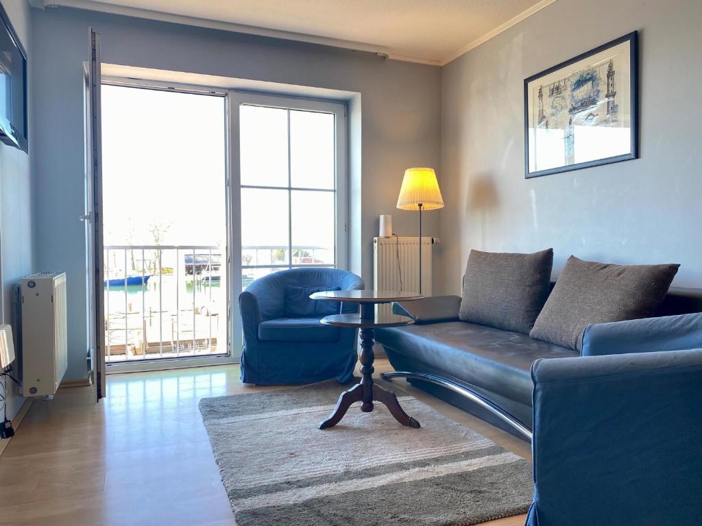 a living room with a couch and a table at Orth B11 - Bestlage mit Hafenblick in Orth