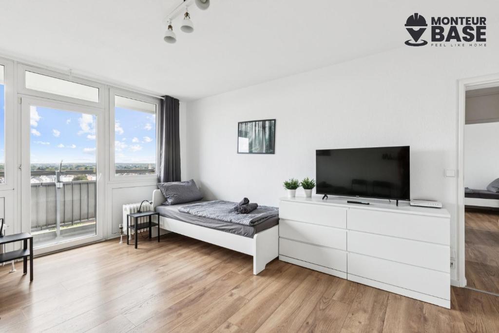 sala de estar blanca con TV de pantalla plana en MONTEUR - Unterkunft für bis zu 6 Personen in 63452 Hanau - HU13, en Hanau am Main