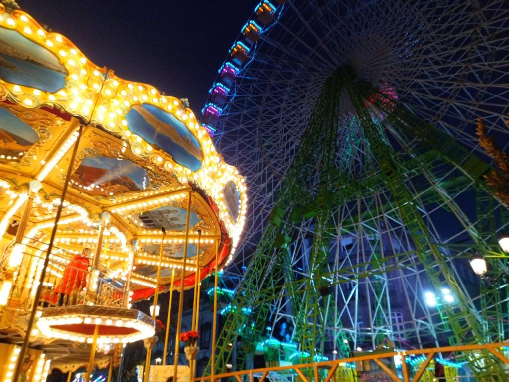 een kermis met een reuzenrad in de nacht bij Hotel Rodeiramar 2A in Cangas de Morrazo