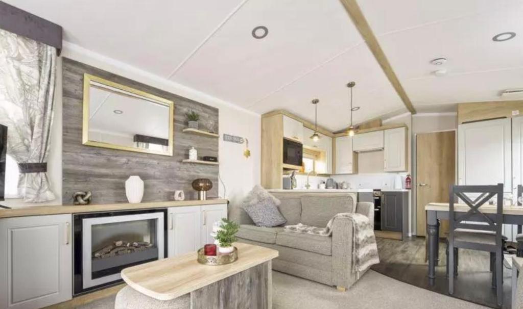 a living room with a couch and a fireplace at Nv48 Luxury static caravan at beautiful durdle door holiday park in West Lulworth