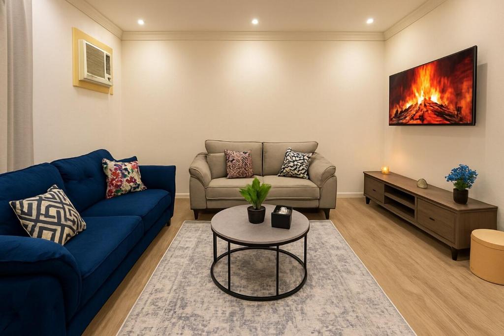 a living room with a blue couch and a table at غرفه وصاله بدخول ذاتي in Jeddah
