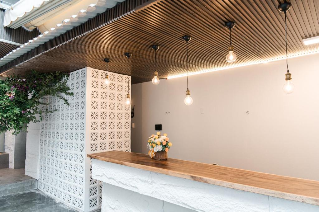 un vestíbulo con un mostrador de madera con flores en Cashew Inn, en Ho Chi Minh