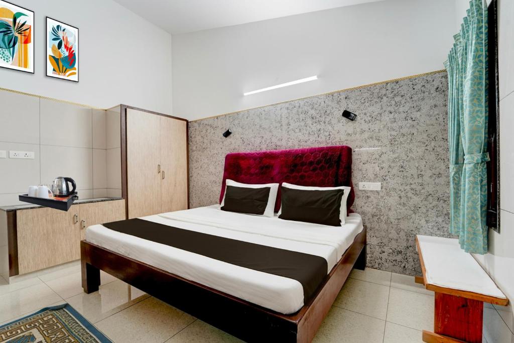 a bedroom with a large bed with a red headboard at Collection O Perumalmalai Bus Terminal Formerly Raja Garden Hill View in Kodaikānāl