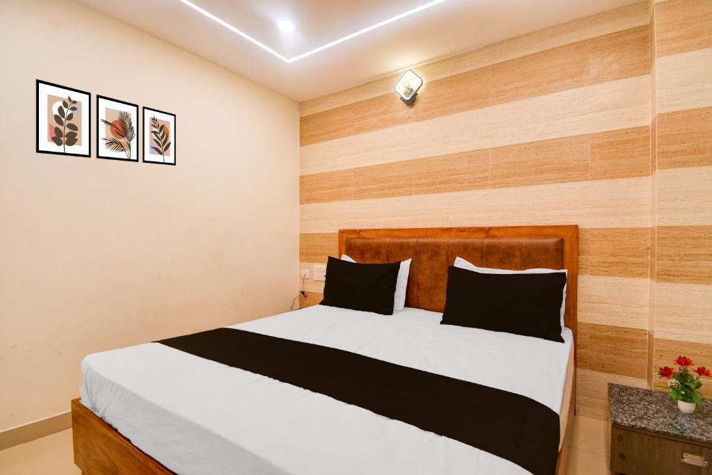 a bedroom with a large bed with wooden walls at Townhouse Gomti Nagar Station Formerly Budget In in Gomti Nagar