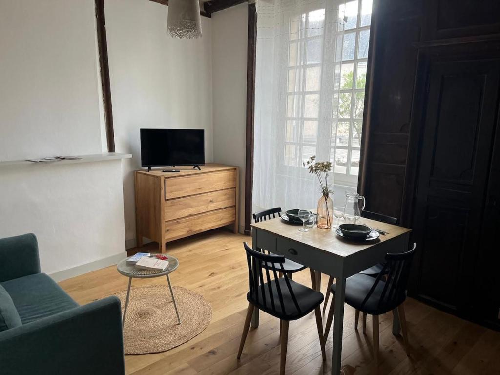 a living room with a table and chairs and a television at T2 Centre ville - rdc in Angers