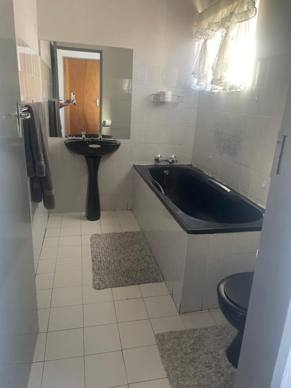 a bathroom with a tub and a toilet and a sink at 33 Boeren in Vryheid