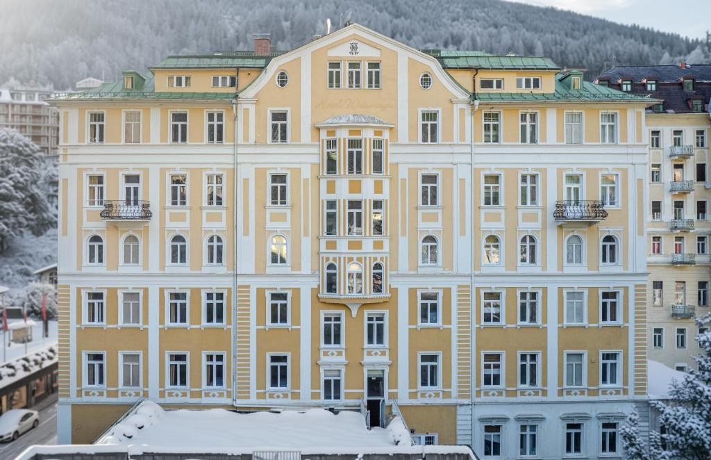 a large yellow building with snow in front of it at the eighteen86 by keyone in Bad Gastein