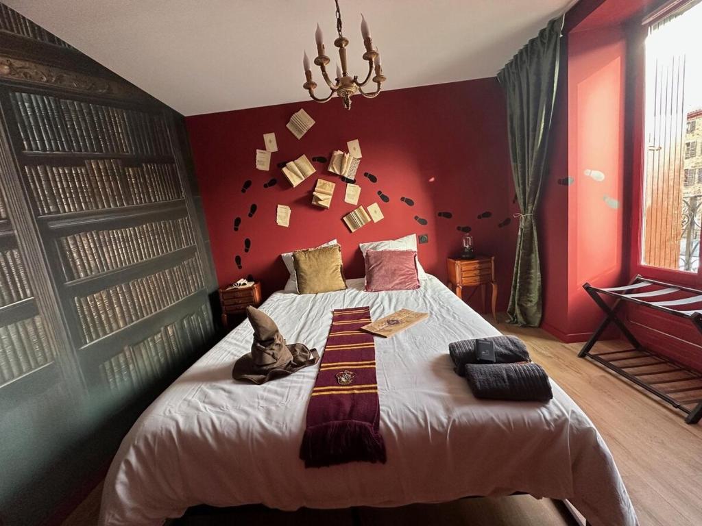 a bedroom with a bed with a red wall at Le Nimbus by Clem in Pélussin