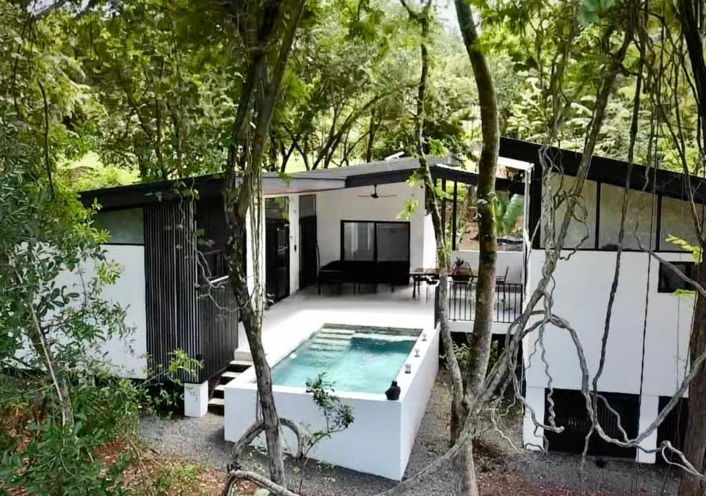 une maison dans les bois avec une piscine dans l'établissement Mermaid House, à Matapalo