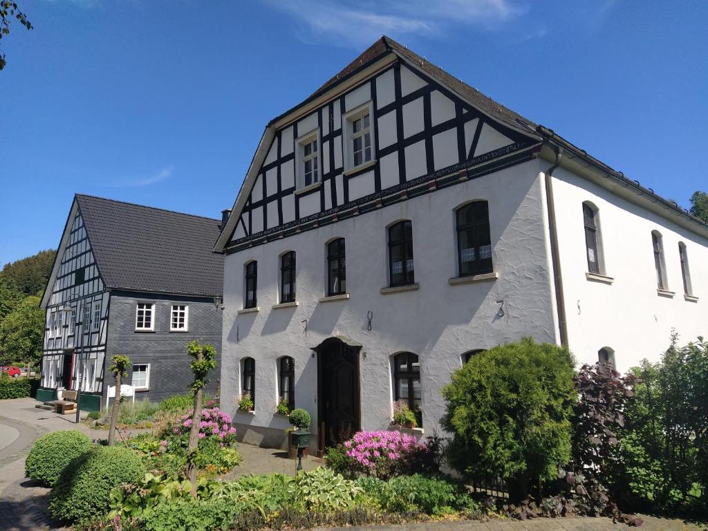 a large white building with a black roof at Ferienwohnung Sauerland Burgfenster in Bilstein